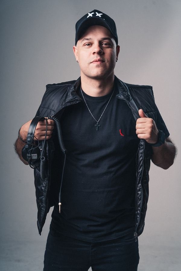 Edd Barros DJ de colete aberto, em retrato de estúdio.