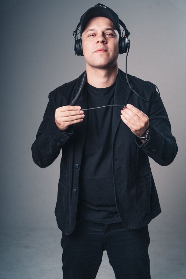 Edd Barros DJ de jaqueta preta, com o fone na cabeça.
